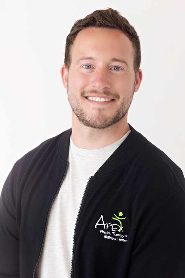 Professional headshot of Casey Sailer, a smiling man wearing a jacket with a logo, depicting a friendly and approachable demeanor.