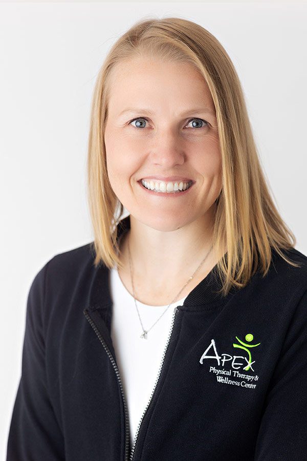 A professional portrait of a smiling woman wearing a jacket with the "Kameron Ihry Hodem Apex Physical Therapy & Wellness Center" logo.