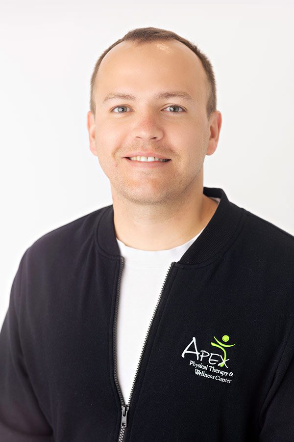 A smiling man in professional attire with a logo that hints at a physical therapy or wellness center, identified as Josh Sorvig.