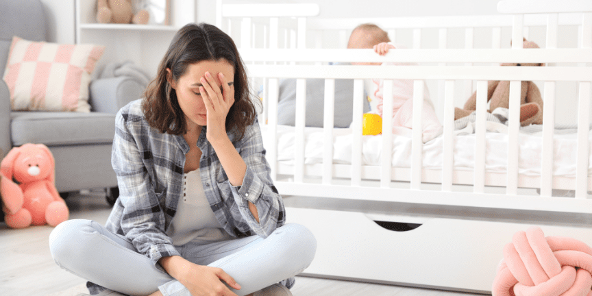 frustrated mom with baby in crib